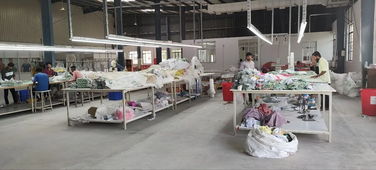 Garment production floor at Macrofast's Annur unit with worktables and sewing stations