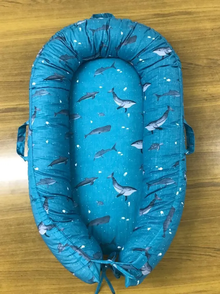 Finished organic cotton baby nest with an all-over whale print