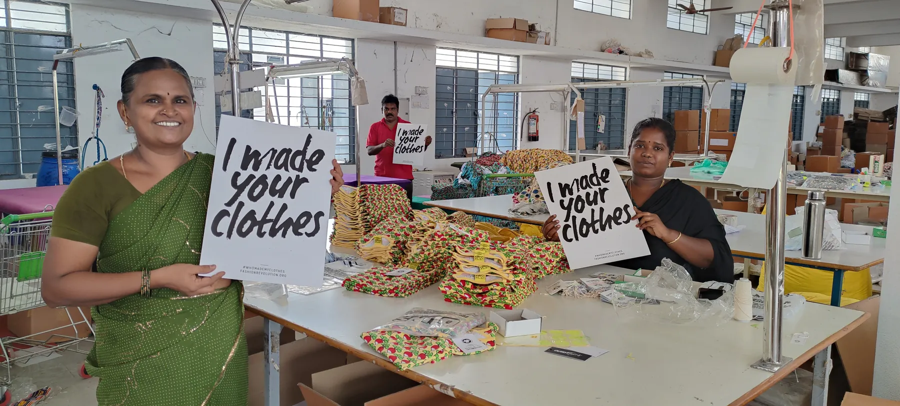 Macrofast's Annur sewing team holding I made your clothes signs on the garment production floor